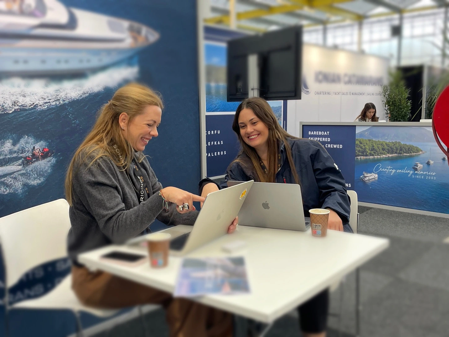 two girls working for yacht4less in a meeting at a yacht show